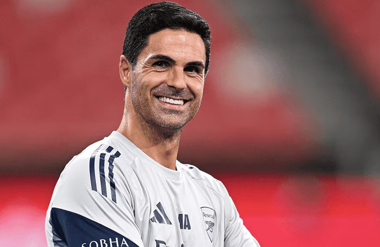 Mikel Arteta smiling in Arsenal training apparel during 2026